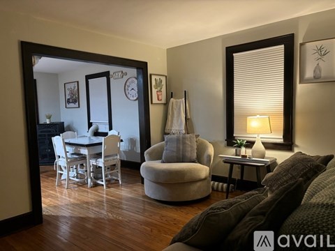 A living room with a grey couch and a white dining table.