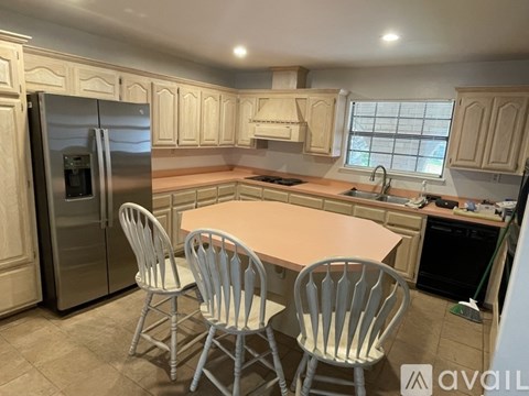 A kitchen with a table and chairs.