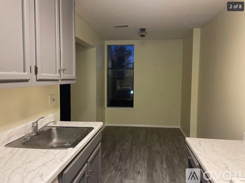 A kitchen with white cabinets and a marble countertop.