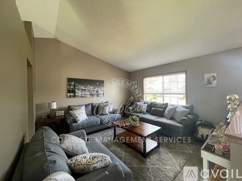 A living room with a grey couch and a coffee table.