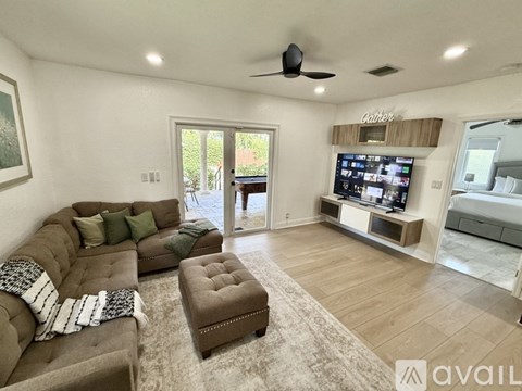 A living room with a brown couch and a flat screen TV.