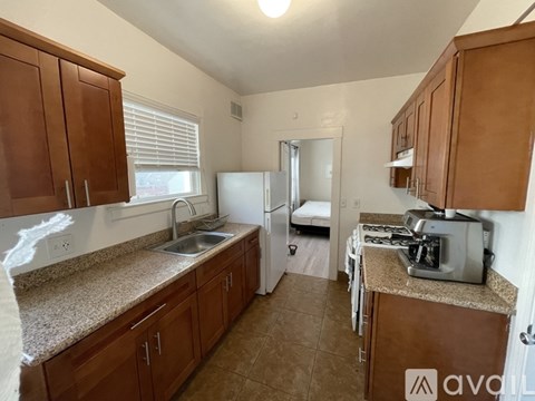 A kitchen with brown cabinets and a granite countertop.