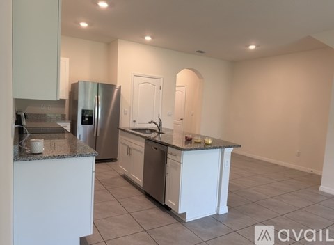 A kitchen with white cabinets and a granite countertop.