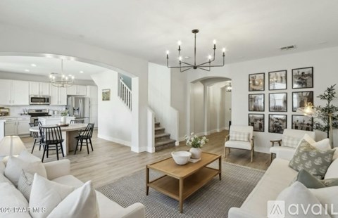 A modern living room with a wooden coffee table and a staircase in the background.
