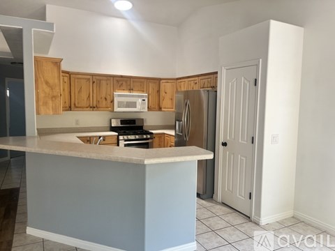 A kitchen with wooden cabinets and a white refrigerator.