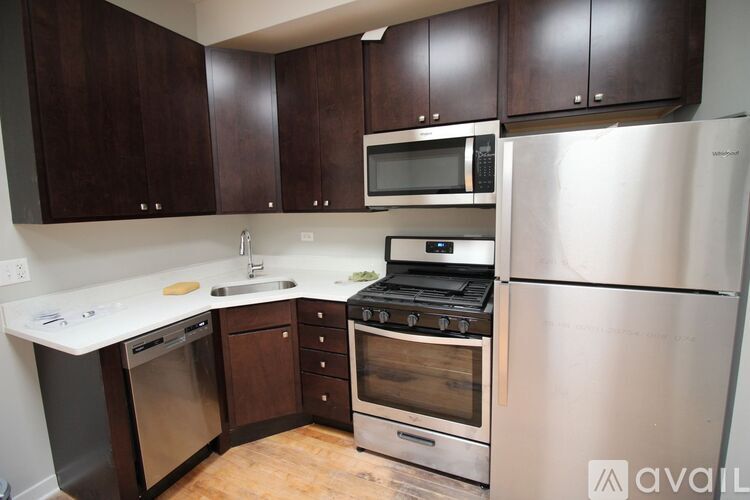 A kitchen with dark brown cabinets and stainless steel appliances.