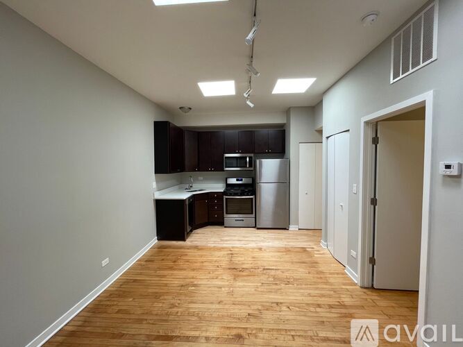 A kitchen with wooden floors and stainless steel appliances.