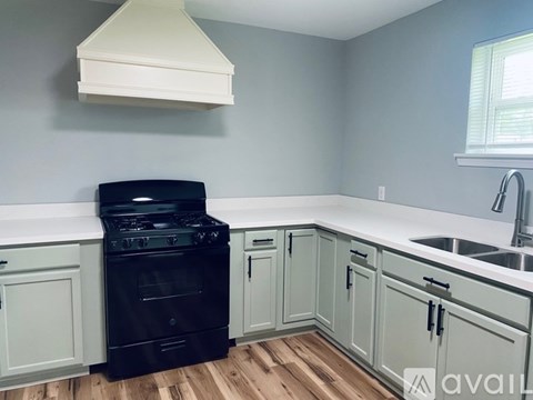A kitchen with a black oven and cabinets.