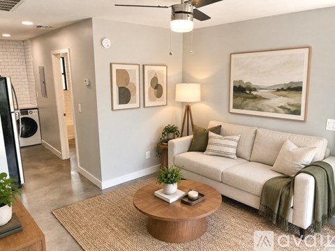 A kitchen with a stainless steel refrigerator, microwave, oven, and washing machine.