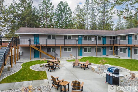 A building with a blue door and a green door is surrounded by trees.