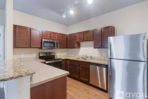 A kitchen with brown cabinets and a granite countertop.
