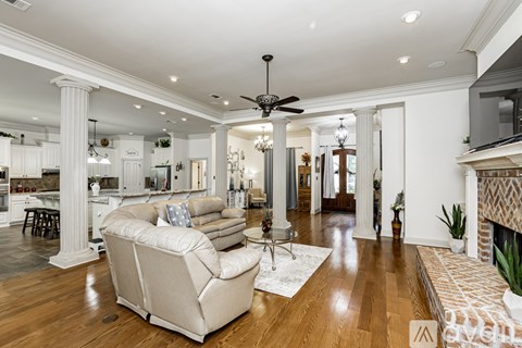A spacious living room with a beige sofa and a fireplace.