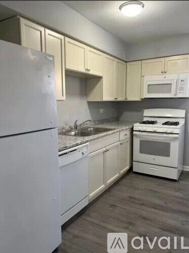 A kitchen with white appliances and cabinets.