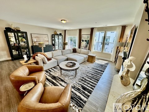 A living room with a brown leather chair and a grey sofa.