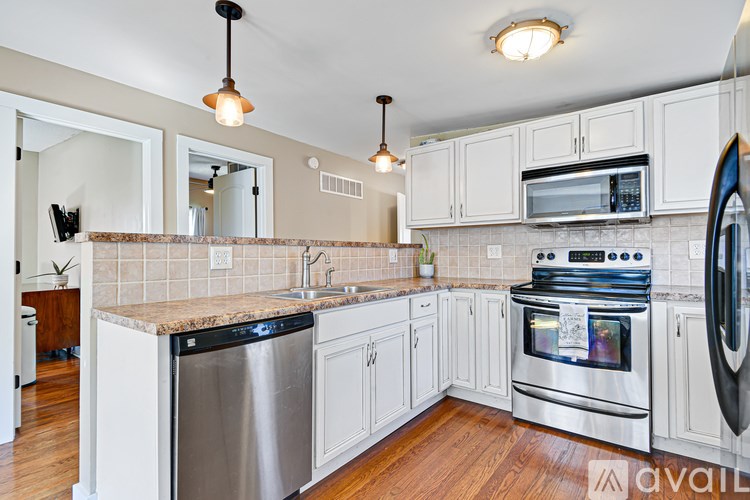 A kitchen with white cabinets and a black dishwasher.