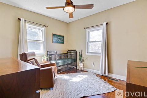 A living room with a brown couch and a ceiling fan.