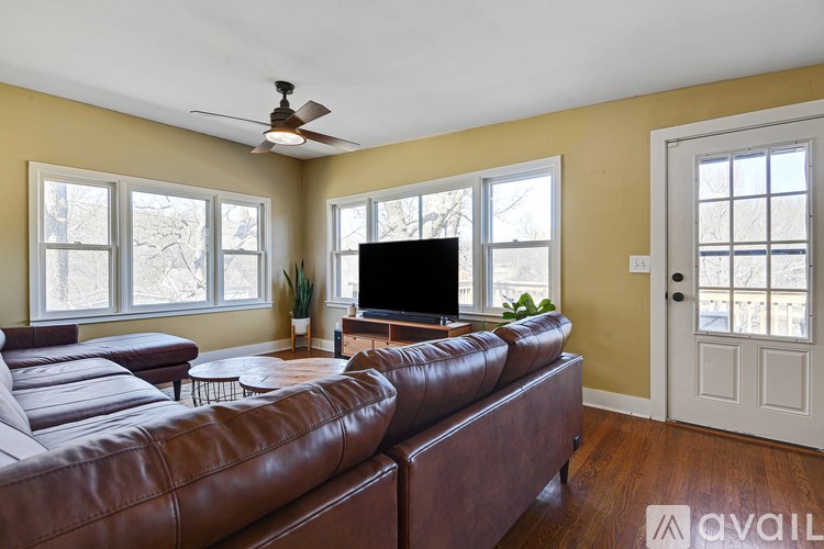 A living room with a brown leather couch and a flat screen TV.