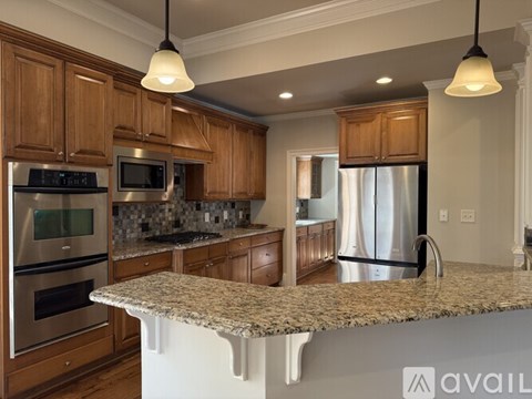 A kitchen with wooden cabinets and granite countertops.