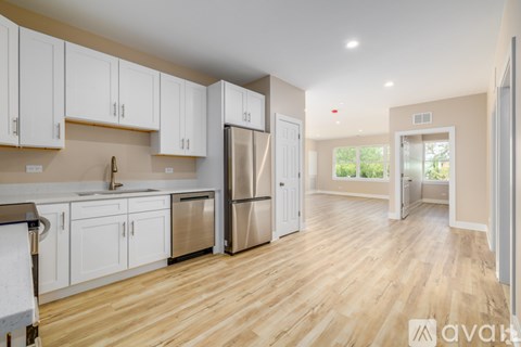A kitchen with white cabinets and a refrigerator.