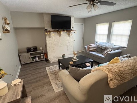 A living room with a grey couch and a white wall.
