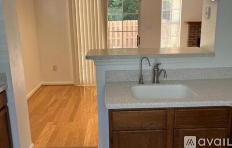 A kitchen with a sink and wooden floors.