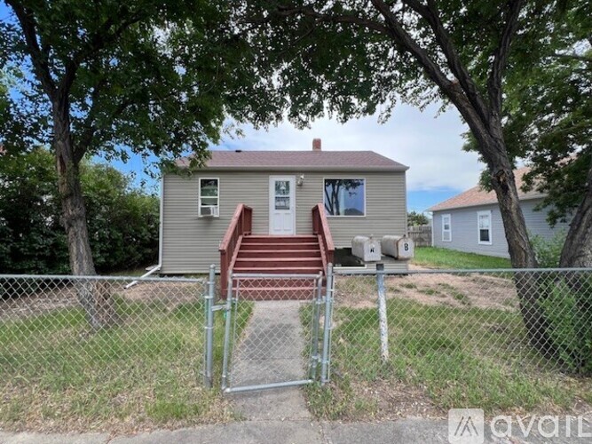 A house with a grey siding and a brown deck.