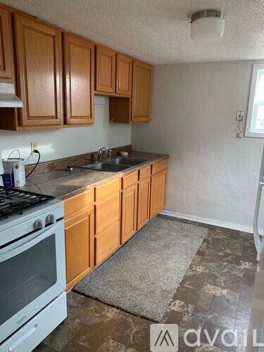 A kitchen with wooden cabinets and a white stove top oven.