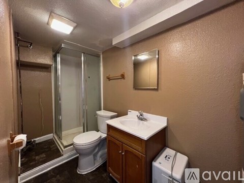 A bathroom with a toilet, sink, and shower.
