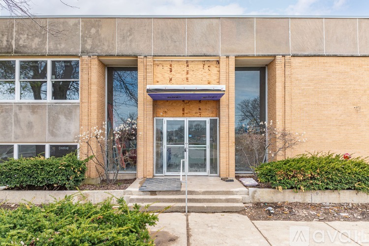 A building with a broken window and a door with a glass panel.