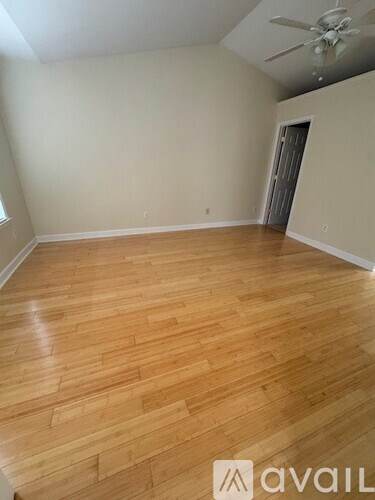 A room with wooden flooring and a ceiling fan.