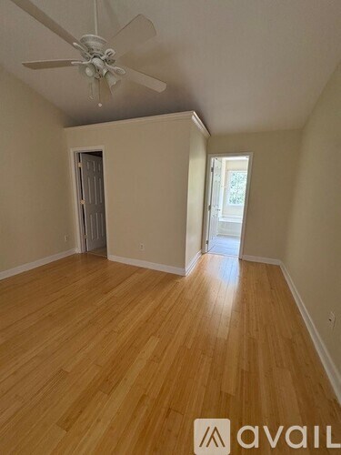 A room with wooden flooring and a ceiling fan.
