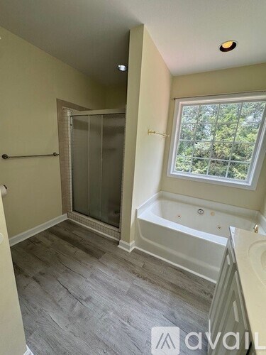 A bathroom with a tub and a window.
