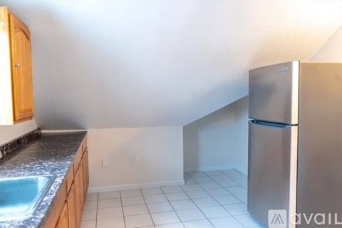 A kitchen with a stainless steel refrigerator and a sink.