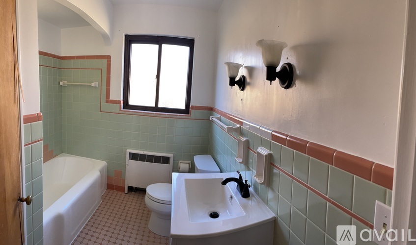 A bathroom with a white tub, toilet, and sink.