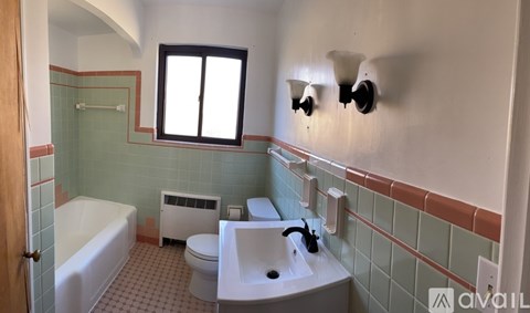 A bathroom with a white tub, toilet, and sink.