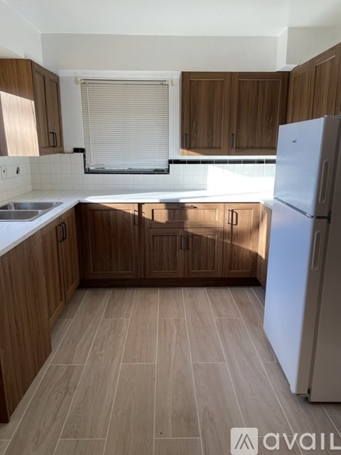 A kitchen with wooden cabinets and a white refrigerator.
