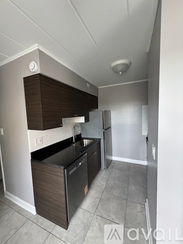 A kitchen with a black fridge and a black dishwasher.