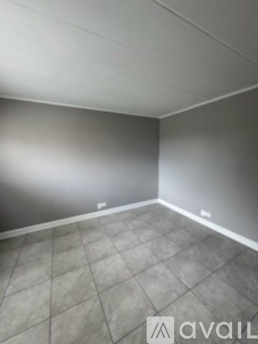 A room with grey tiled flooring and white walls.