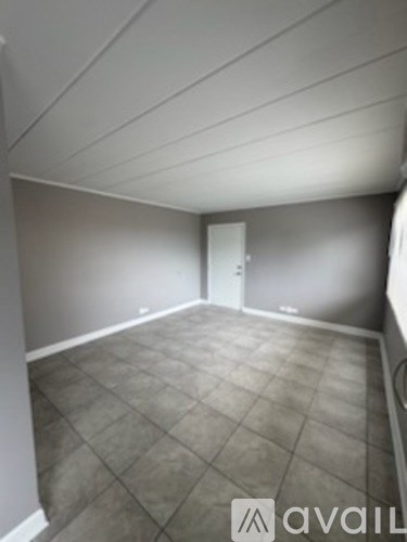 A room with a tile floor and a door in the background.