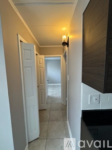 A hallway with a white door and a light on the wall.