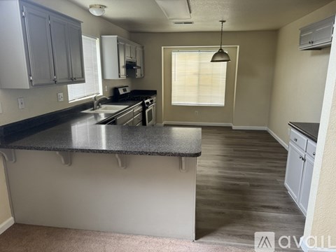 A kitchen with a black countertop and stainless steel appliances.