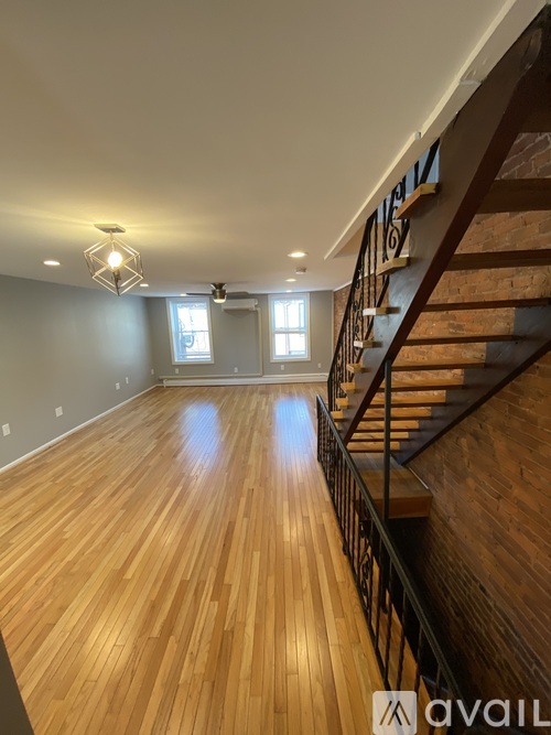 A wooden staircase with a metal railing leads up to a second floor.