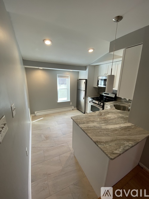 A kitchen with a marble countertop and stainless steel appliances.