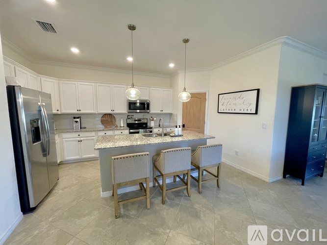 A kitchen with a refrigerator, microwave, oven, and sink.