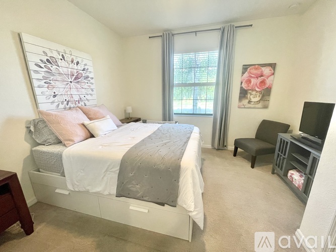 A bedroom with a large bed and a small chair.