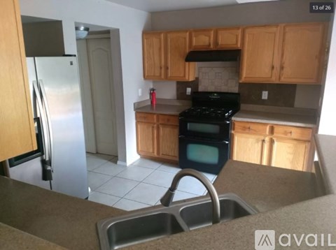 A kitchen with wooden cabinets and a stainless steel refrigerator.