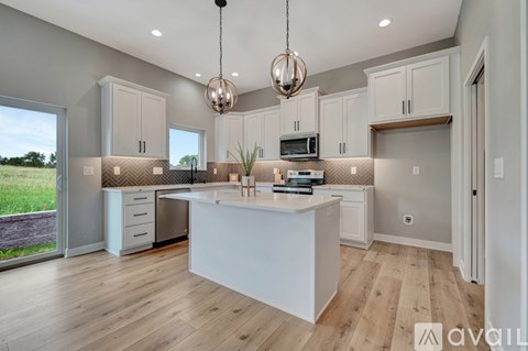 A modern kitchen with a large island and wooden floors.
