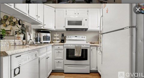 A kitchen with white appliances and cabinets.