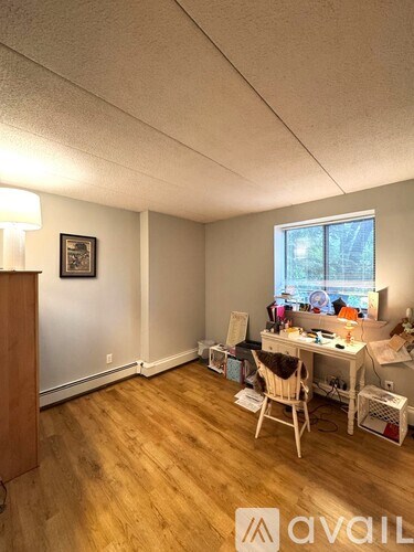 A bedroom with a bed, a dresser, and a window.