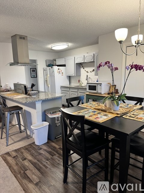 A kitchen with a table and chairs in front of it.